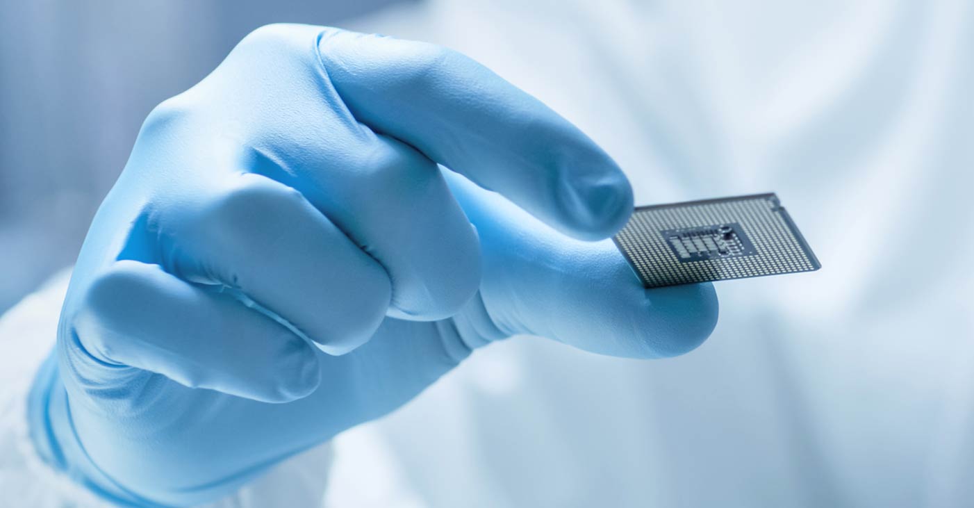 A gloved hand holding microchip
